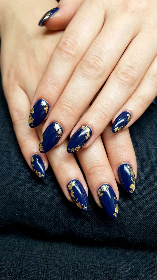 15 Blue Nails Ideas That Are Stunning, Versatile, and Always in Style 11 Deep Ocean Blue Nails With Gold Foil